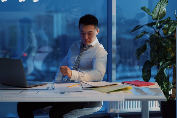 Man sitting at a desk looking down at notes